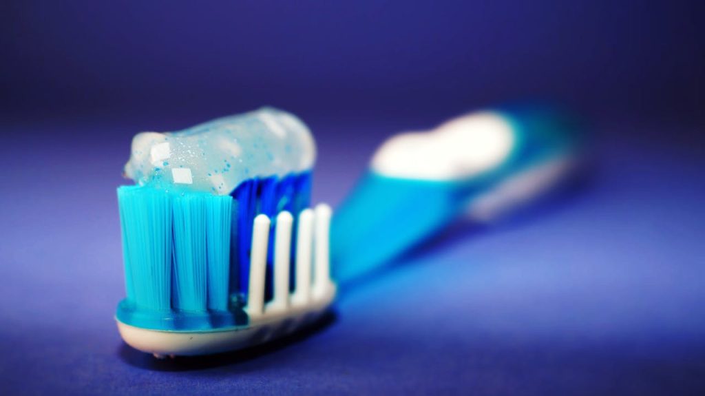 Cepillo de dientes con pasta dental azul ideal para diferentes tipos de boca