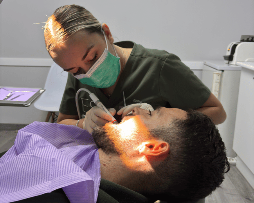 Dentista realizando una limpieza dental profesional a un paciente