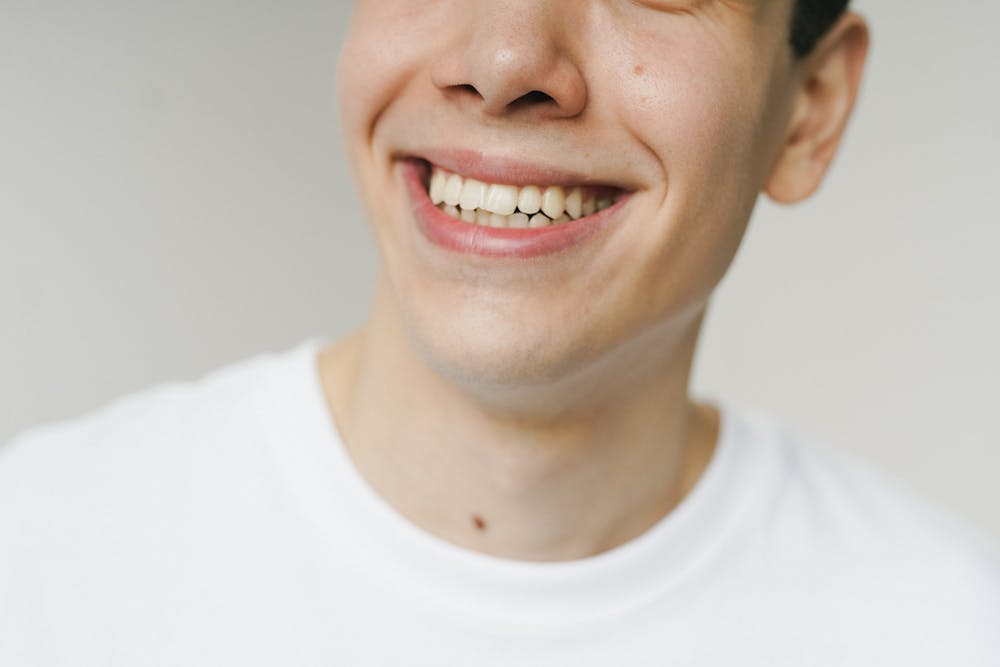 Persona mostrant un somriure sa després d'una neteja dental professional