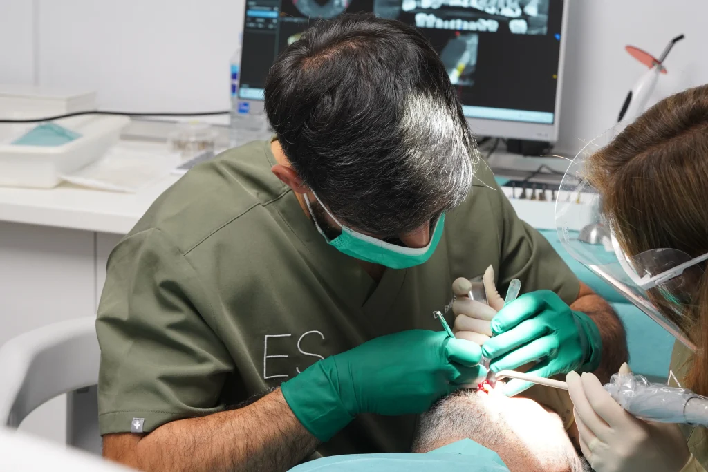 Dentista trabajando en un paciente utilizando herramientas dentales avanzadas en un tratamiento dental