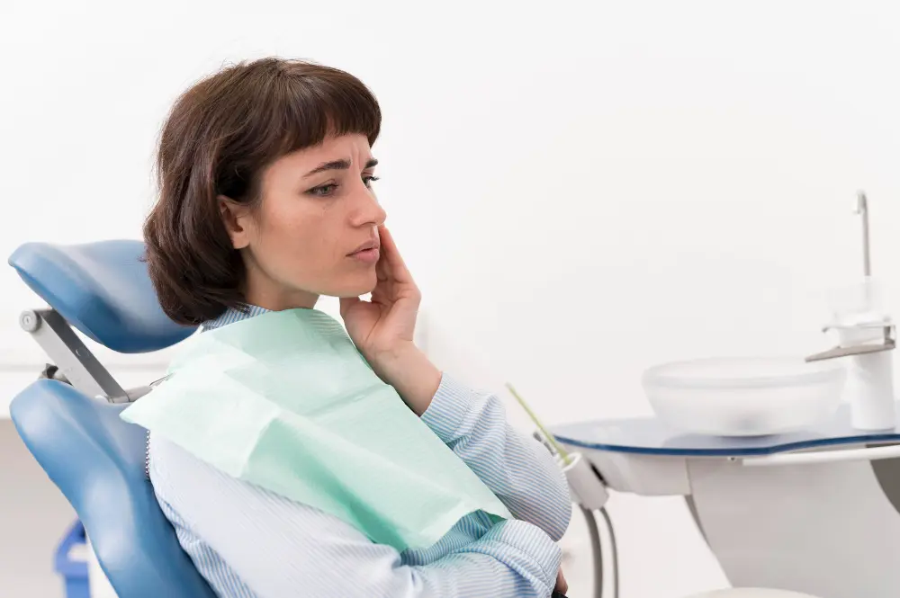 Mujer con dolor de muelas en la consulta dental, posible indicio de bruxismo